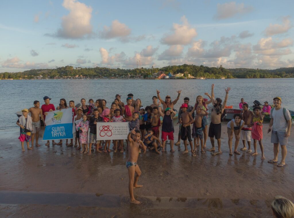 Children and volunteer posing for a picture near the river